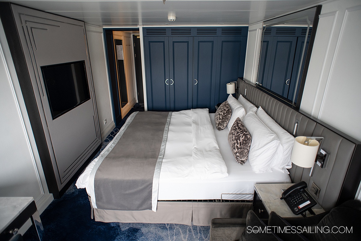 Inside a stateroom on Riverside Mozart river cruise ship, with a king bed and blue and white finishes.