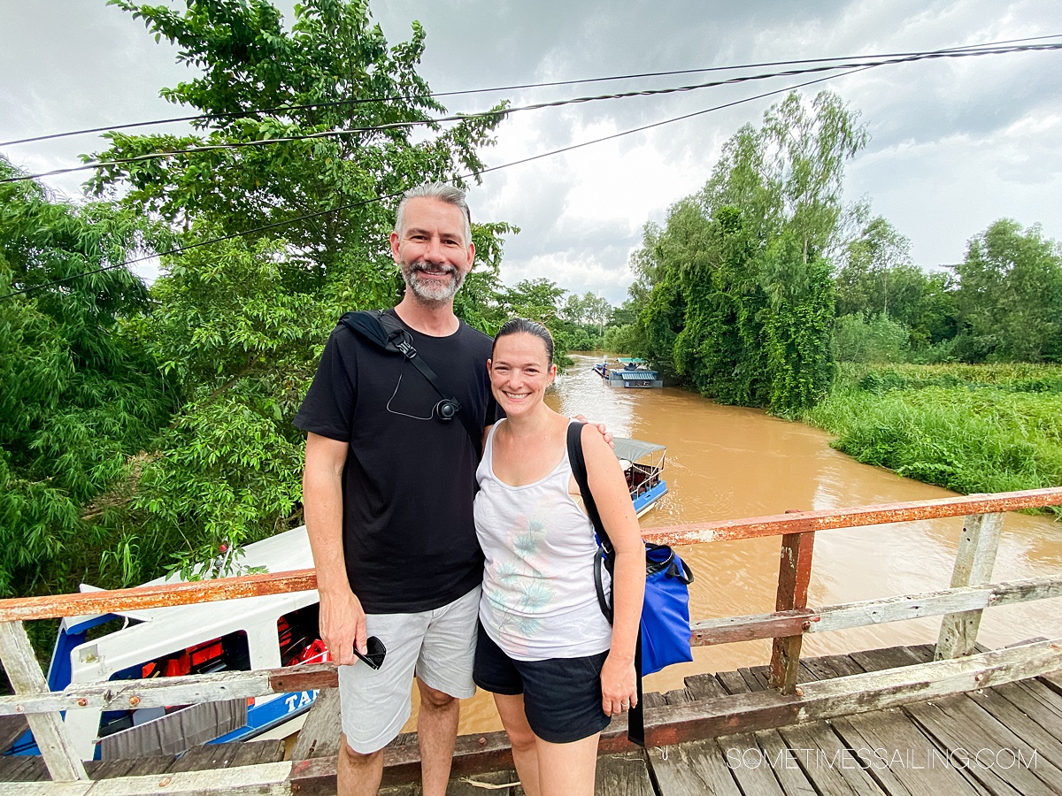 Man and woman standing on a bridge above the muddy water in the Mekong River area during a river cruise excursion with AmaWaterways.