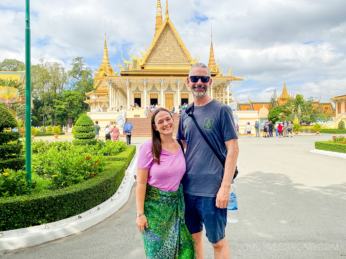 Couple in front of an ornate Southeast Asian palace building in Cambodia.