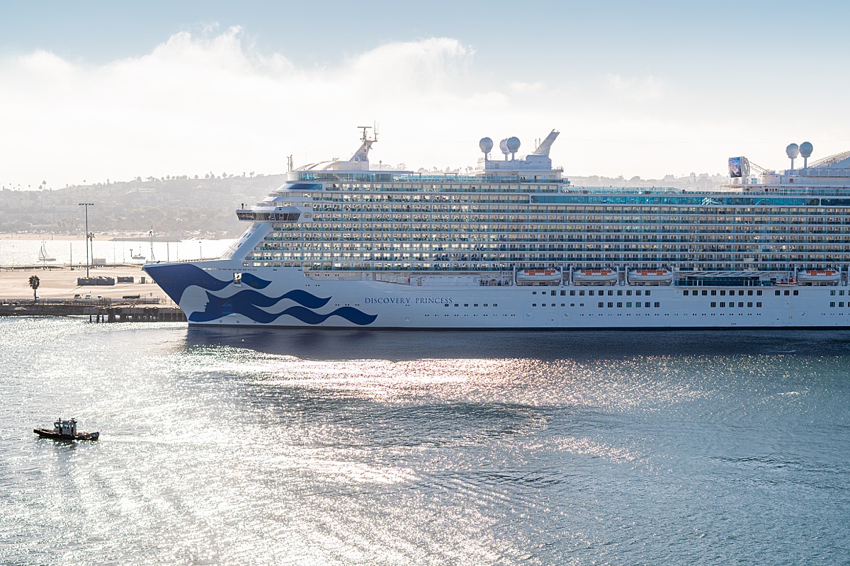 Discovery Princess cruise ship in the distance with the sun reflecting on the ocean.