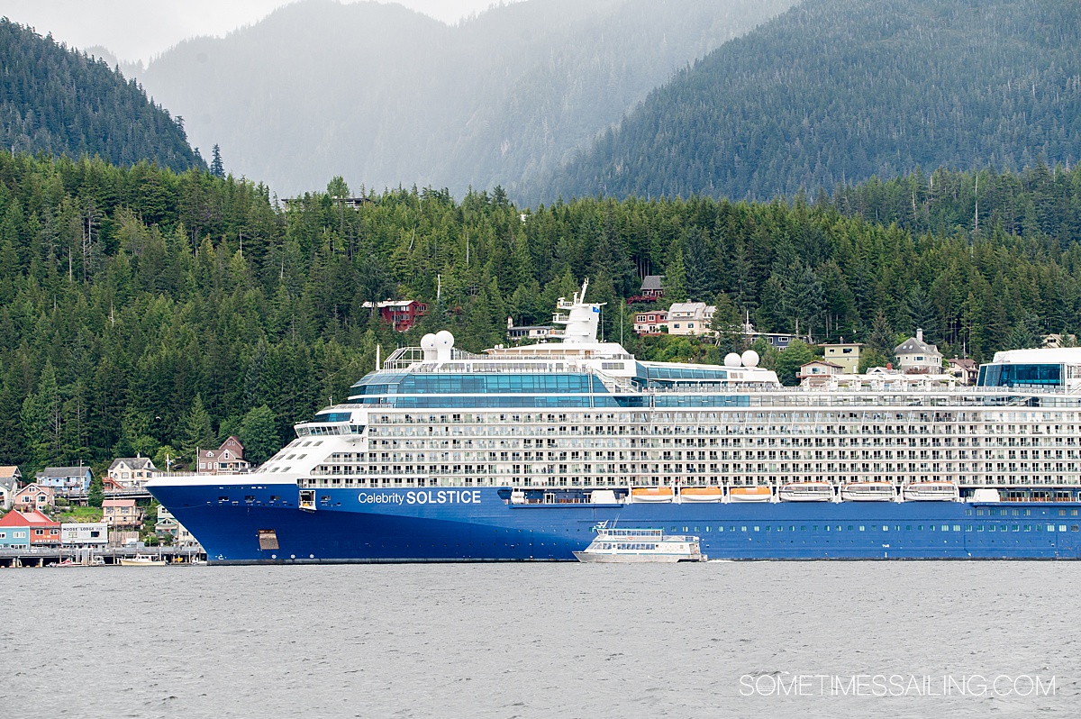 Celebrity Solstice cruise ship in the distance with evergreen trees behind it in Alaska.