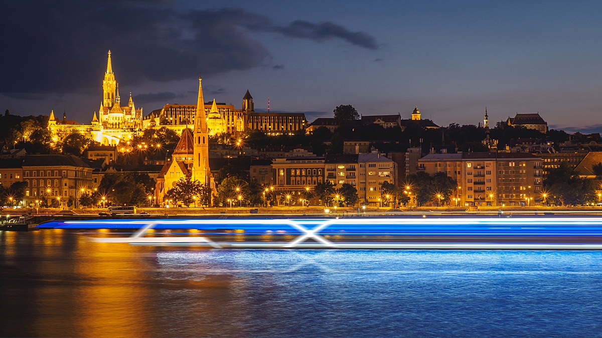 Celebrity Cruises slow shutter lights image on the Danube River in Budapest, with a signature "X" sailing by.