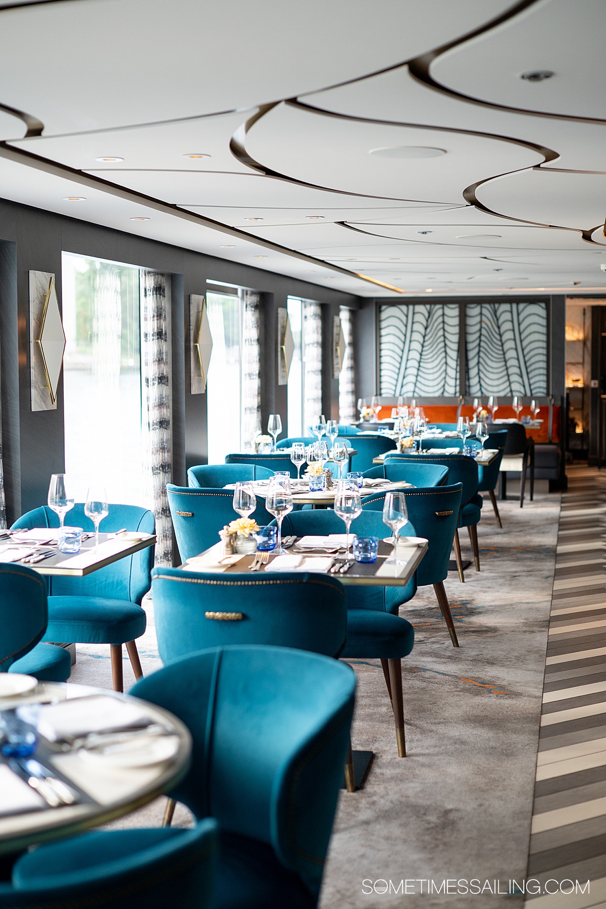 Teal blue chairs in the restaurant area of a river cruise ship.