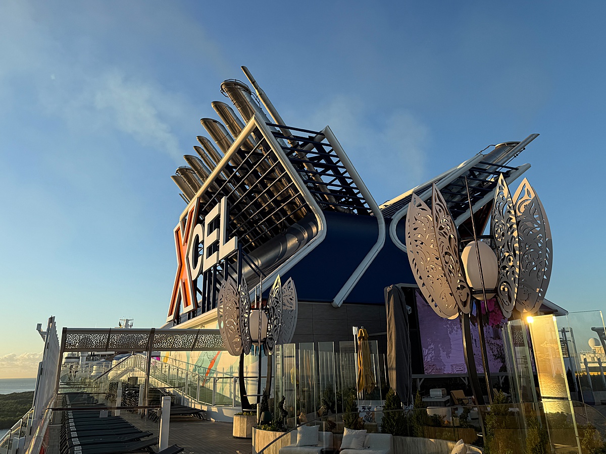 Xcel sign on the side of the ship stack in blue, white and orange letters.