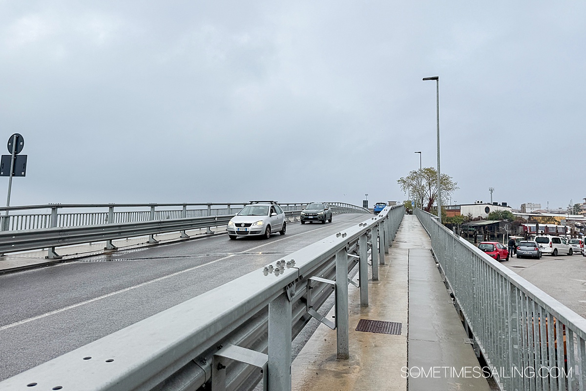 Overpass on a gray day with a walkway and cars.