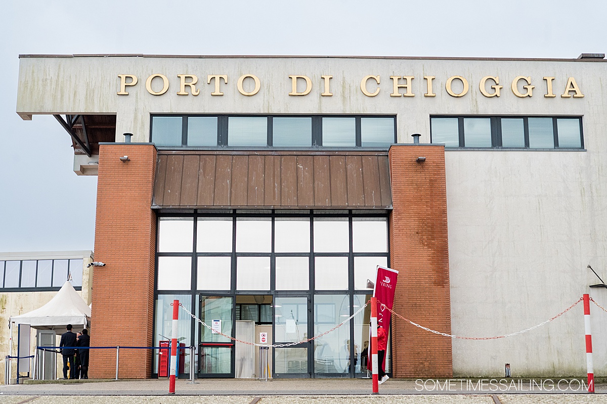 Port of Chioggia building in Italy with gold letters on top and a boxy building design.