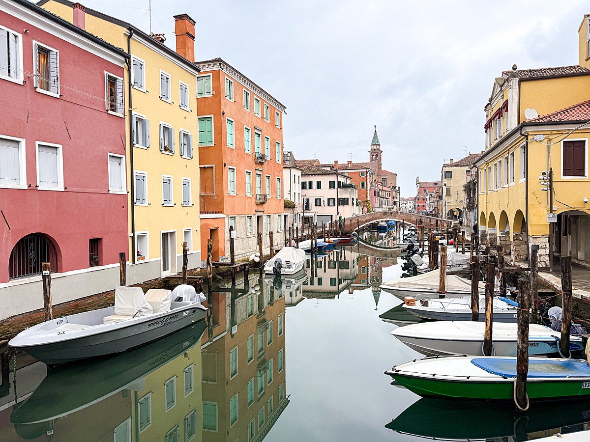 Canal Vena in Chioggia, Italy, with colorful buildings and boats in the water.