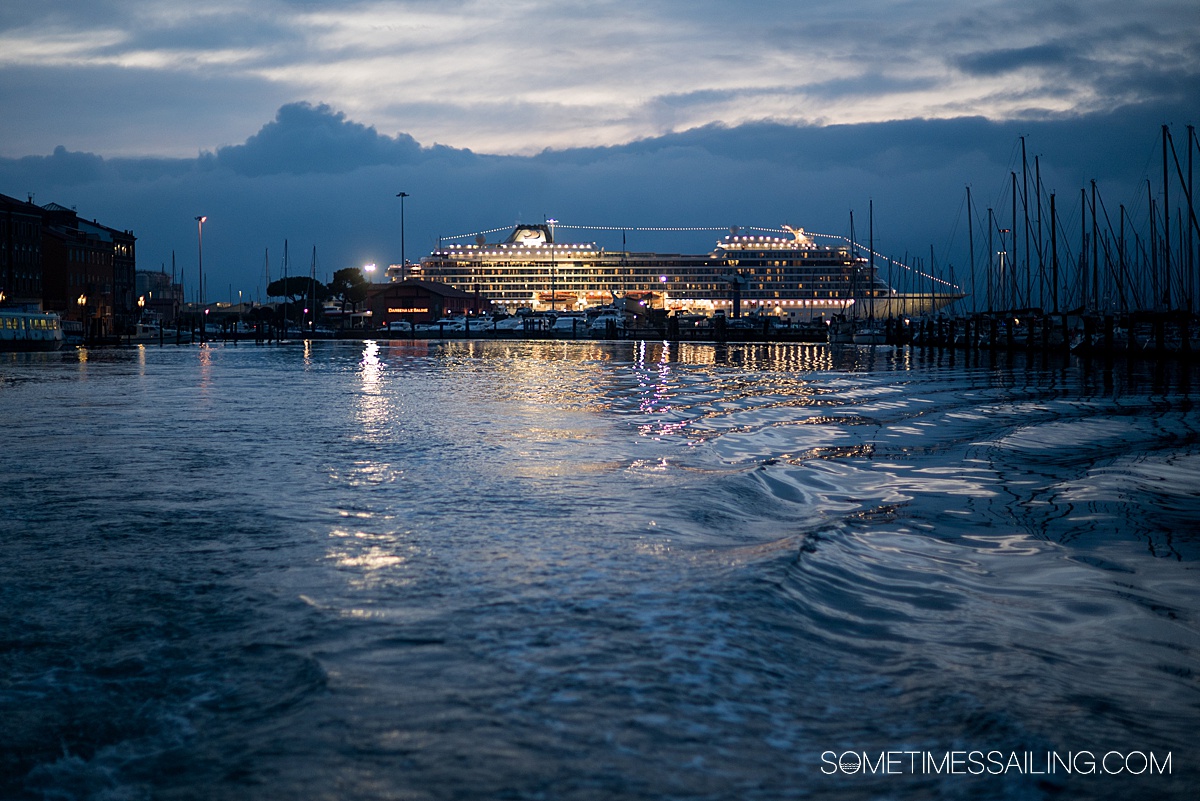 Viking Ocean cruise ship in the distance with a dusk sky and nighttime lights.