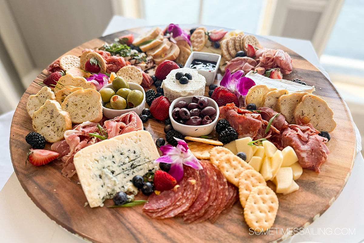 Charcuterie and cheese platter with crackers and olives.
