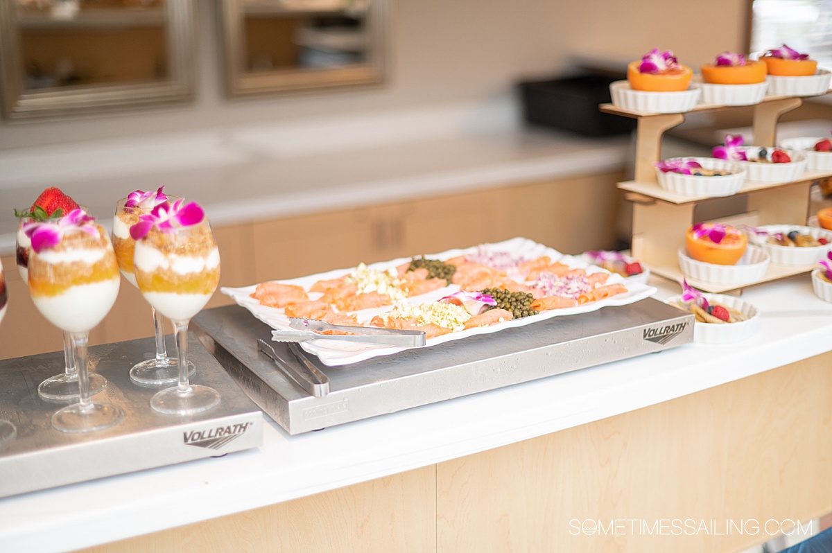 Yogurt glasses and a smoked salmon platter with a three-tier display of grapefruit halves on American Cruise Lines buffet.