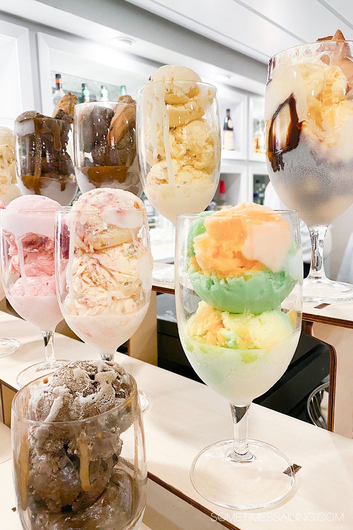 Ice cream sundaes lined up on a multi-tiered display with colorful ice cream flavors.