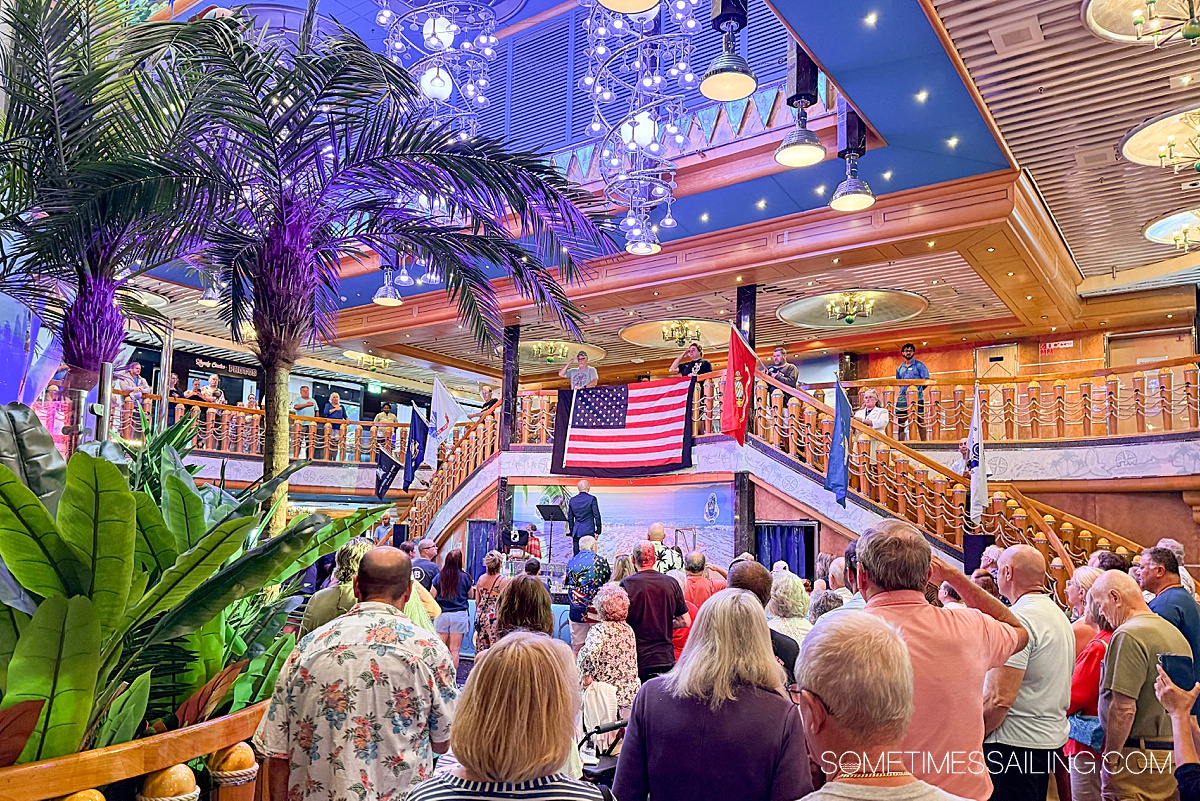 Veterans and active military with the American flag hung from the staircase balcony.