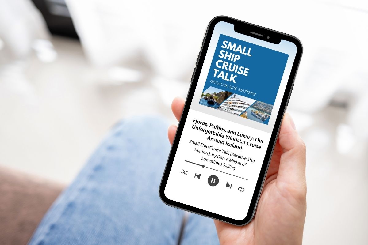 Hand holding an iPhone with a podcast on the screen, Small Ship Cruise Talk