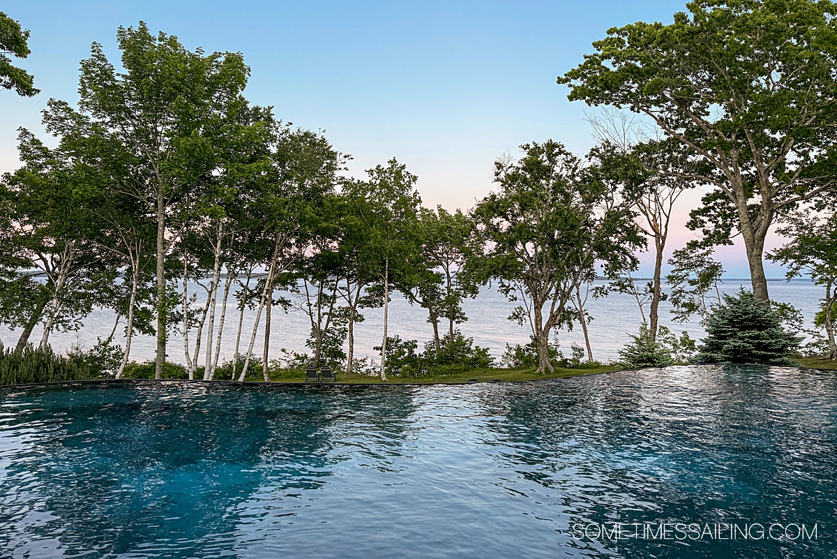 Infinity pool that reaches out to a horizon of green deciduous birch trees.