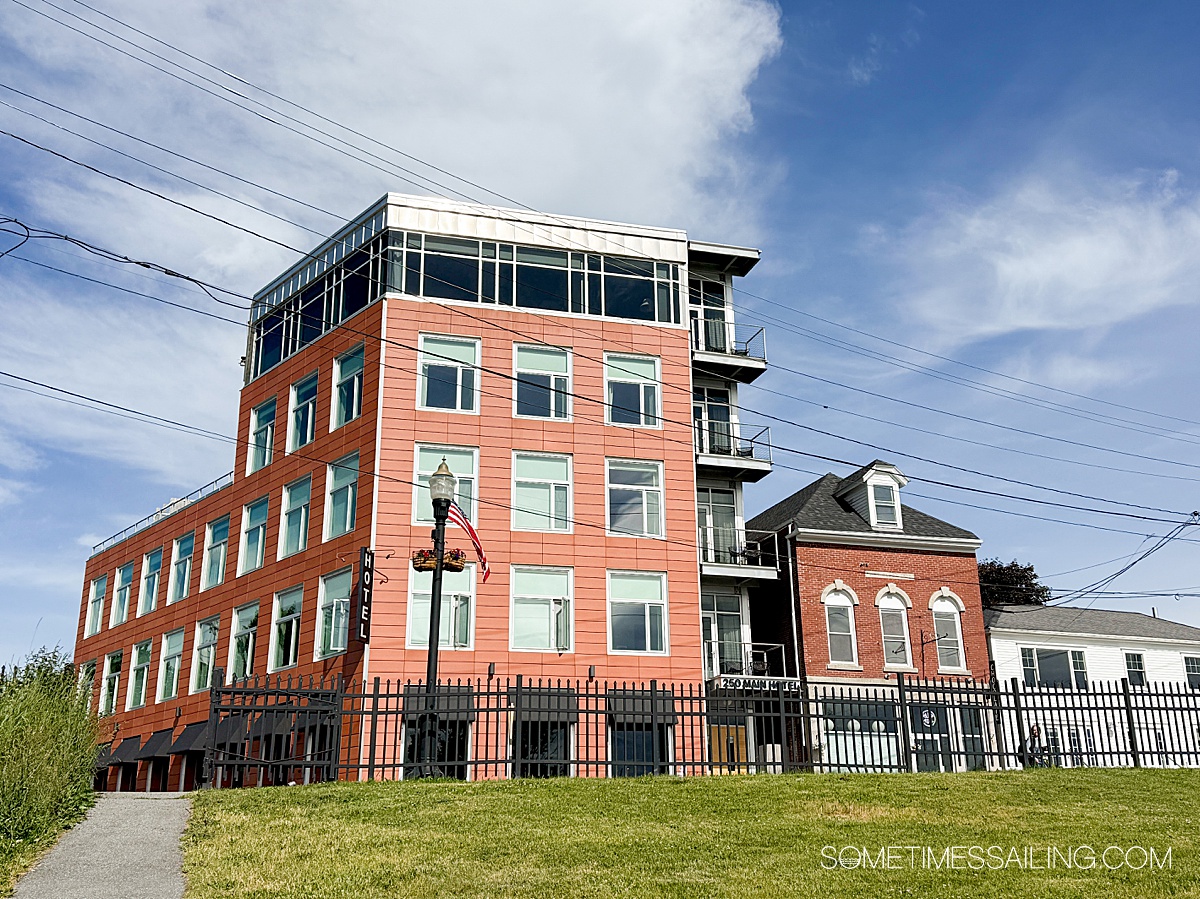 Facade of a building against a blue sky and green grass.