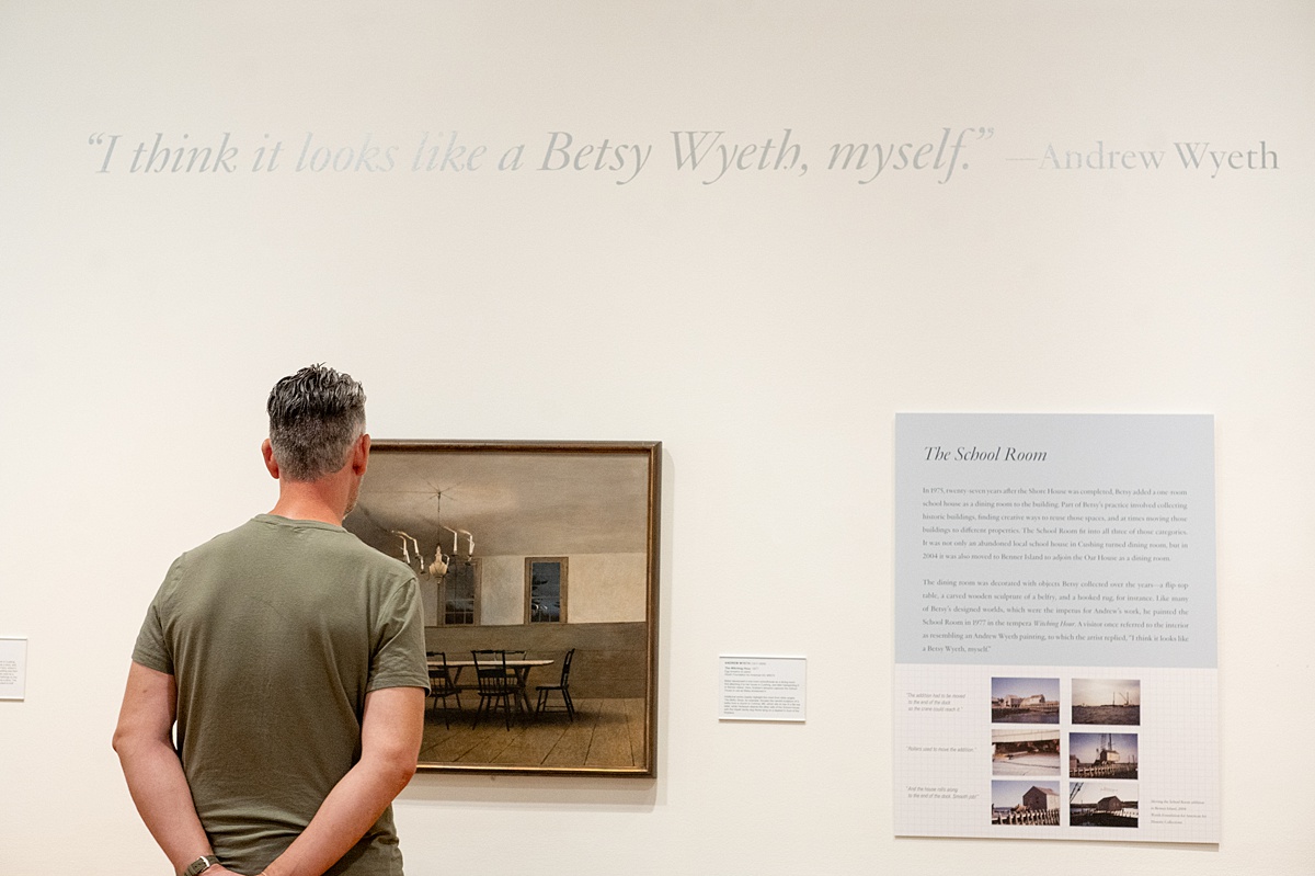 A man looking at a painting in a wall at an art museum called the Farnsworth, in Maine.