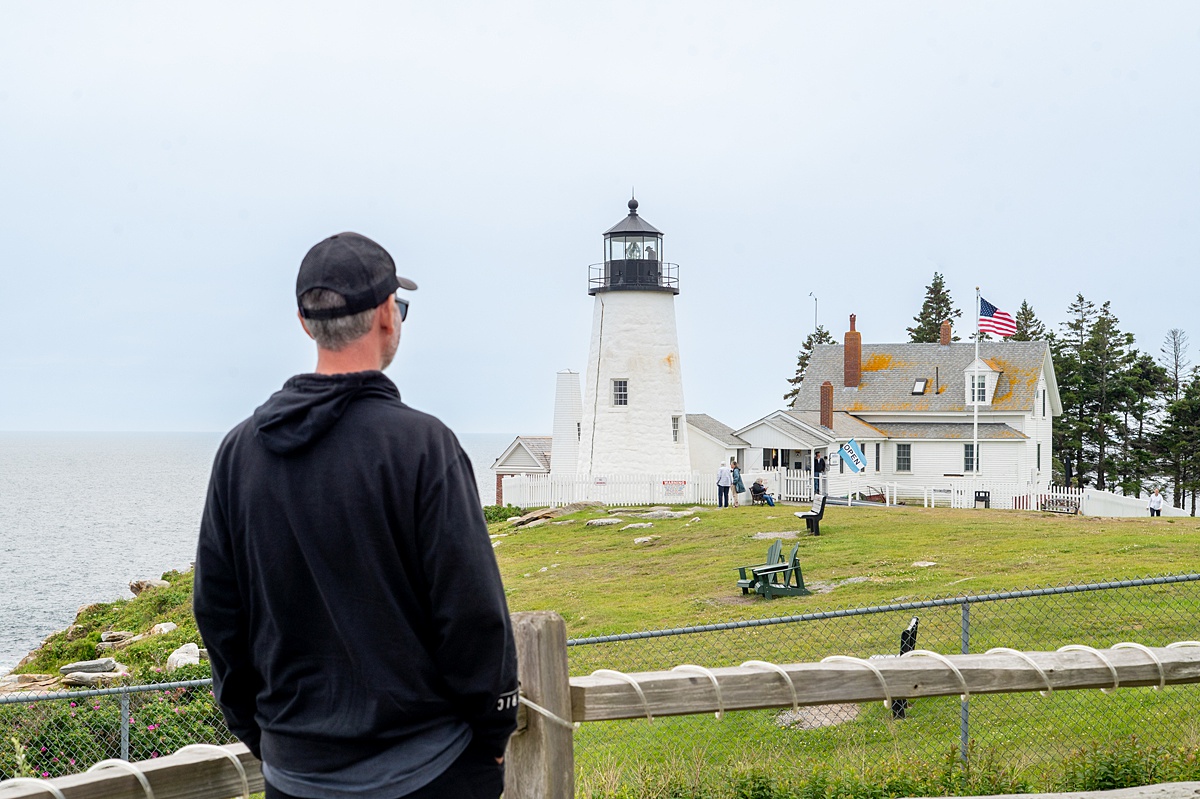 Main looking at a white lighthouse and home in the distance.