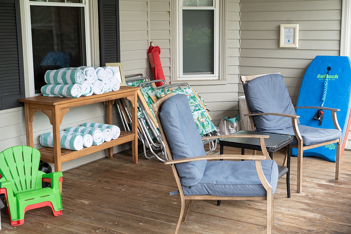 Front porch of a hotel with chairs and towels.