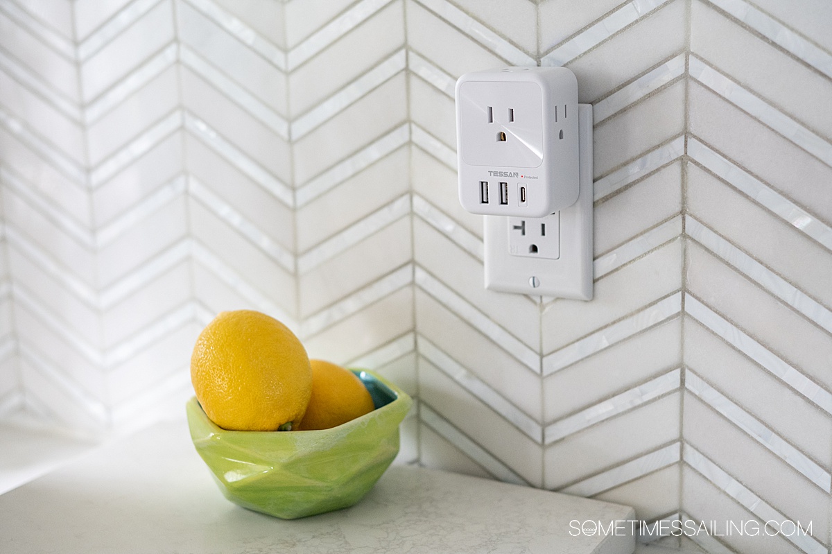 Compact TESSAN Surge protector in front of a white tile backsplash.