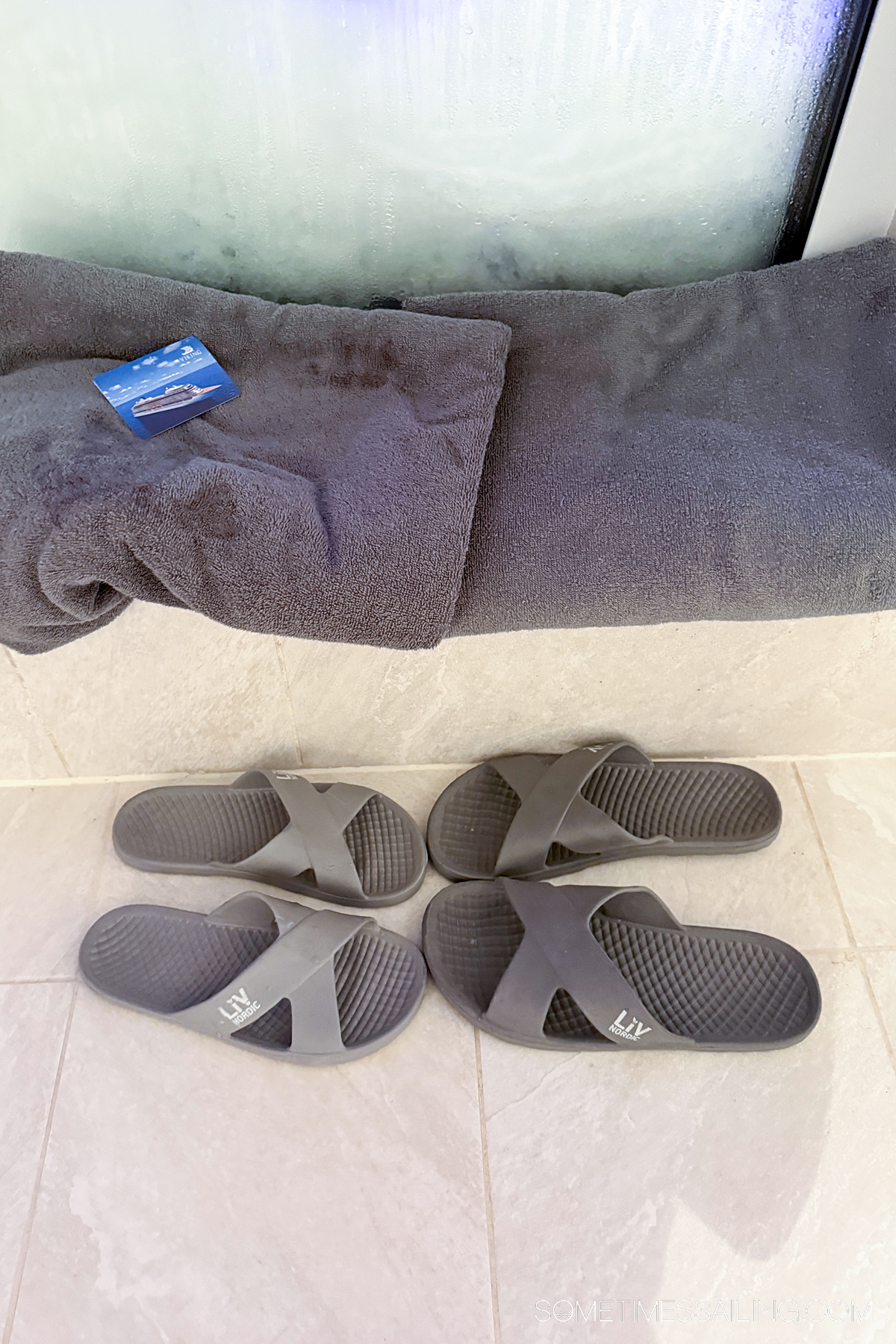 Two pairs of gray sandals and gray towels.